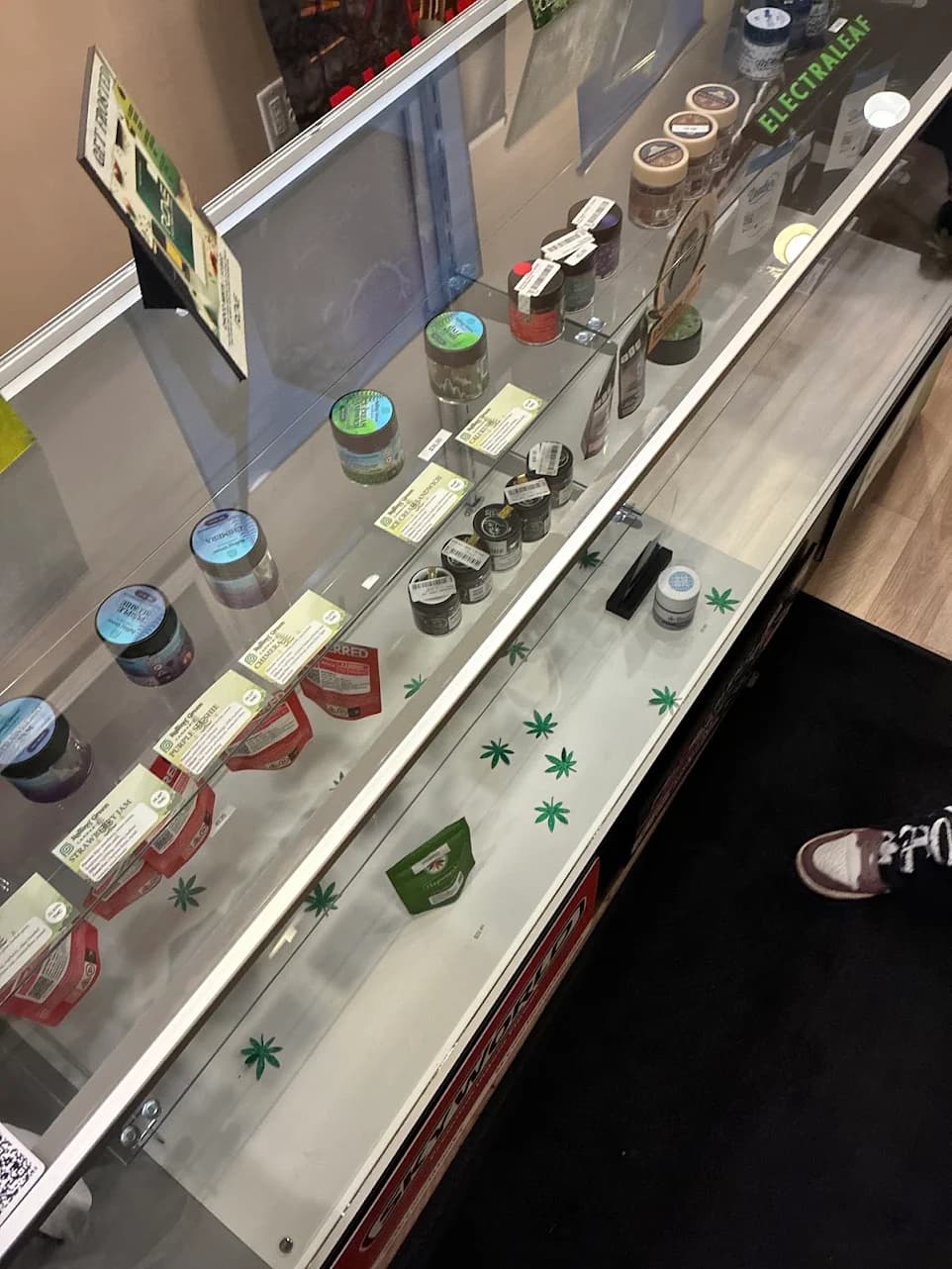 Priced jars and packs on the shelf of the glass display counter at Upstate Exotics in Niagara Falls, NY